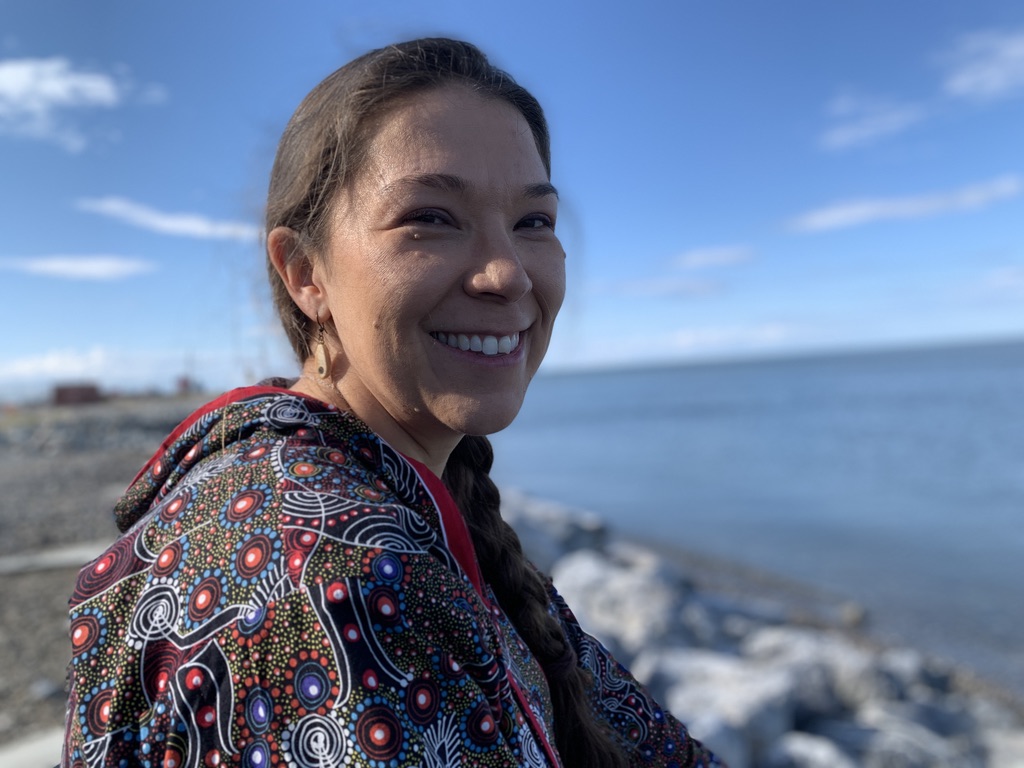 a woman smiles near the shore