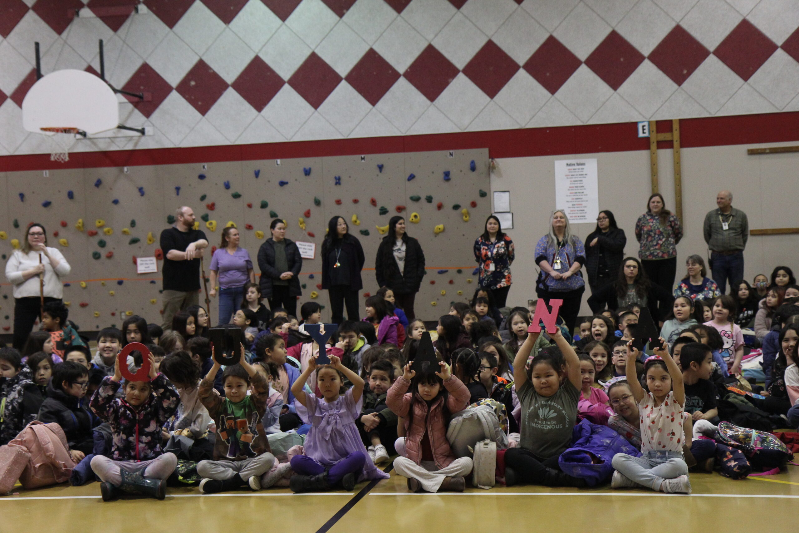 Students at Alaska Native Cultural Charter School hold up letters that read 